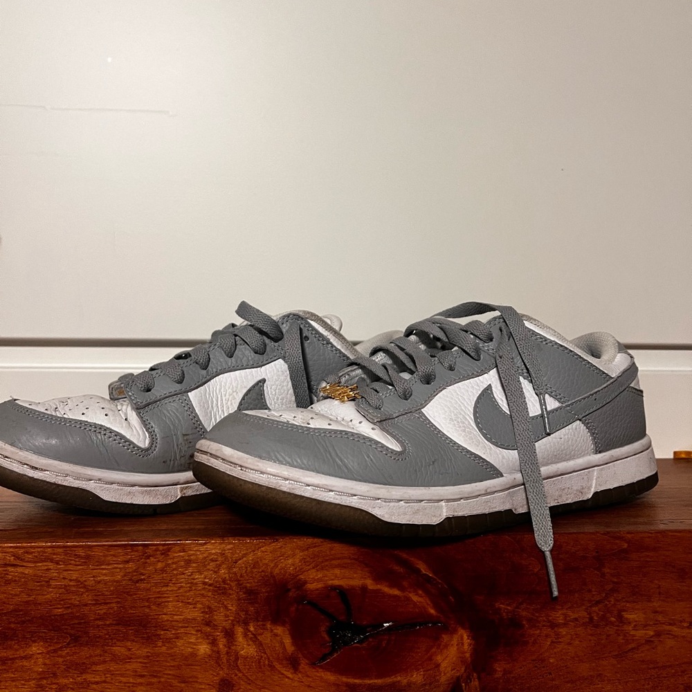 Grey Nike dunks with gold logo